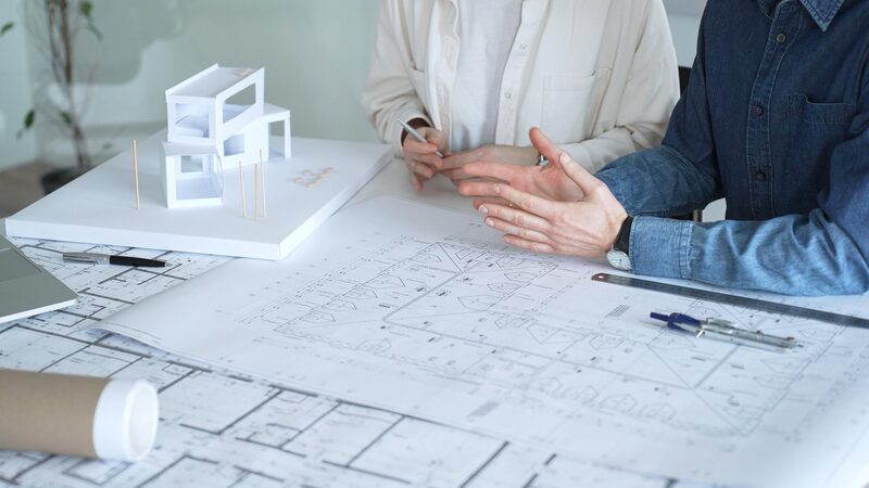 Architects reviewing building plans and scale model
